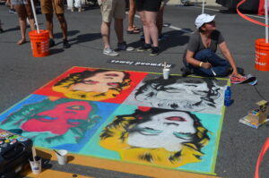Artist talks with viewers while creating chalk images of Marilyn Monroe