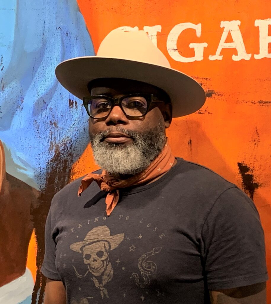 artist Cedric Smith stands in front of one of his paintings