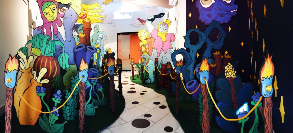 Otherworldly creatures and odd flora are beside a path that crosses an art gallery