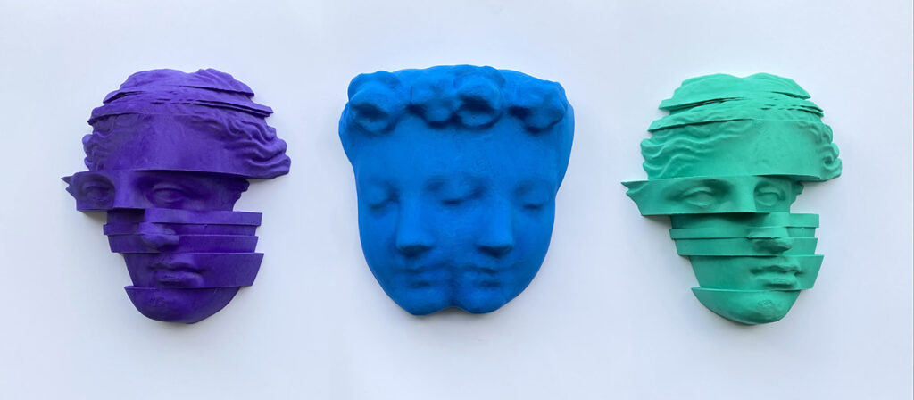 Three resin sculpture of a woman's face in purple, blue and green