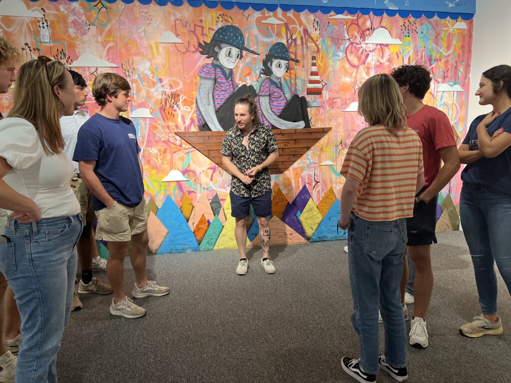 Artist Ramiro Davaro-Comas speaks with AP Spanish students from Deerfield-Windsor School about his exhibition Familias at the Albany Museum of Art.