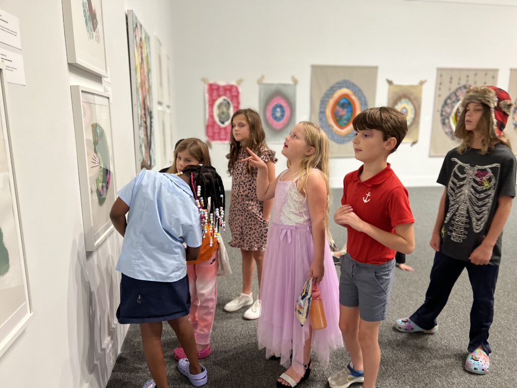 Six elementary school students look at an artwork in the AMA's Haley Gallery.