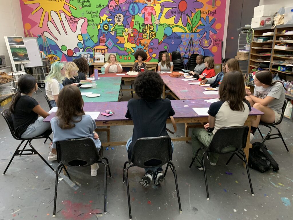 Teenagers are shown sitting around a table in the AMA Classroom.