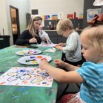 A woman and two children work on an art project