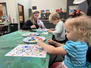 A woman and two children work on an art project