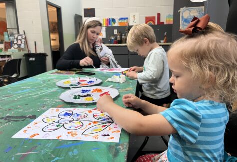 A woman and two children work on an art project