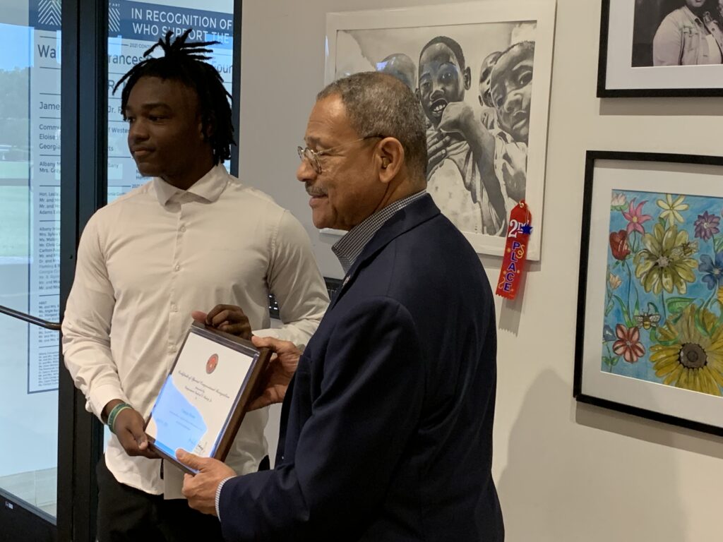 Congressman Sanford Bishop presents Chancie Brown with second place in the 2023 Congressional Art Compeitition