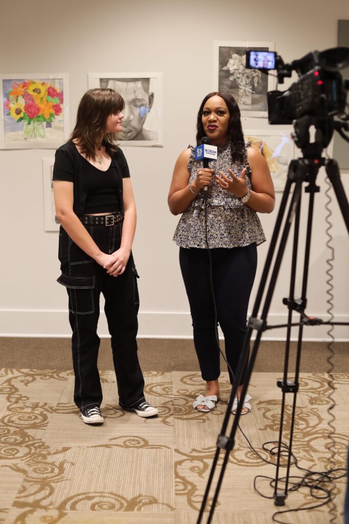 Teen Art Board member is interviewed by a television reporter