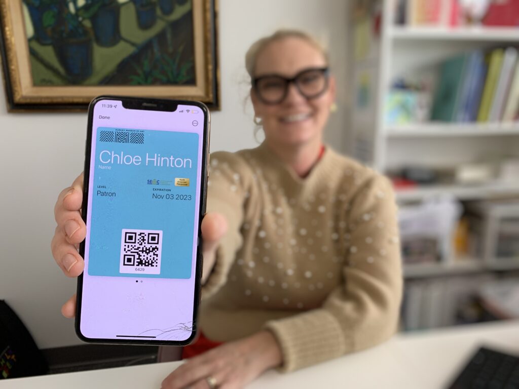 Woman shows smartphone with AMA digital membership card on the screen