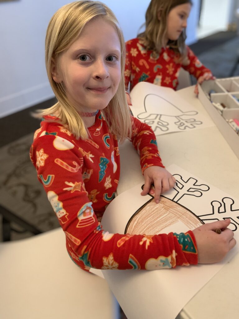 A girl colors a reindeer drawing at the AMA.