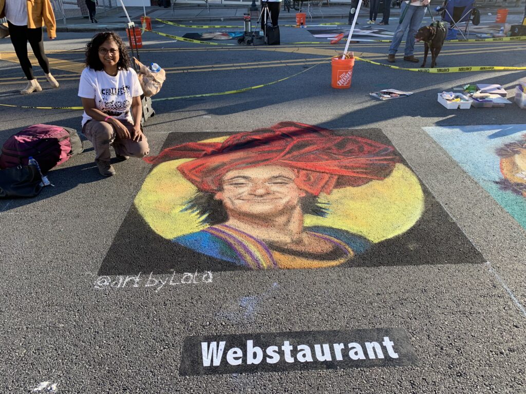 Artist poses with chalk image of man wearing a turban