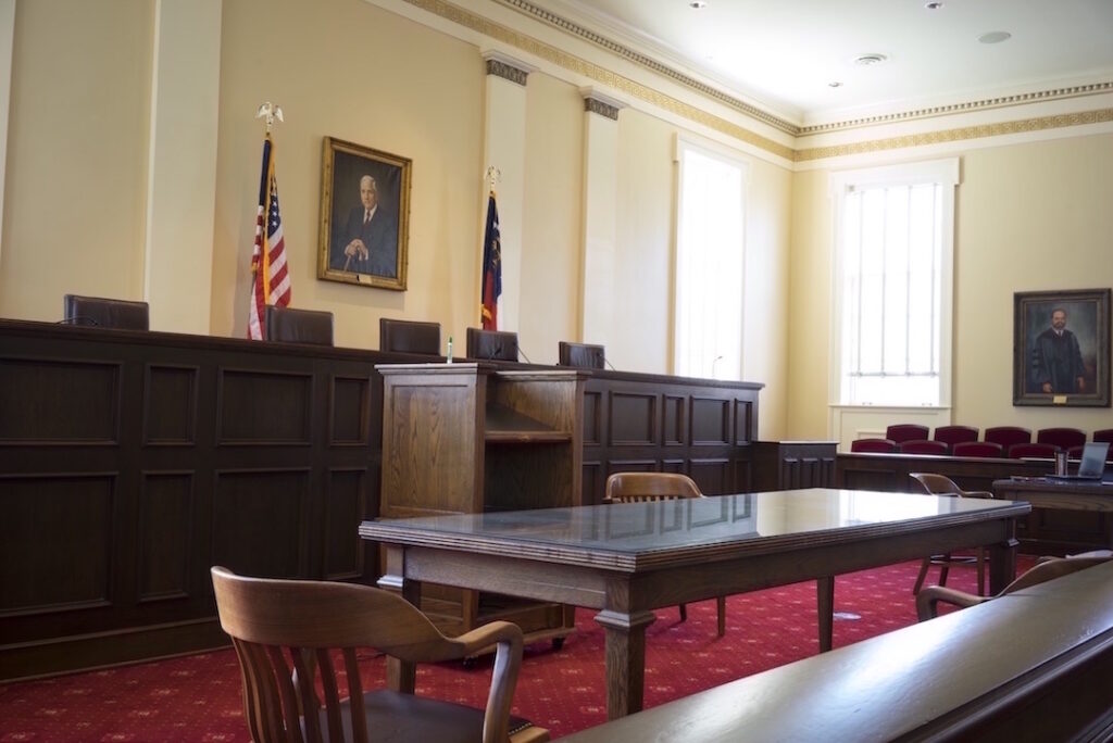 Vacant courtroom with flags and portrait