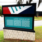 Albany Museum of Art logo in white on a teal background in one face of a three-sided roadside sign