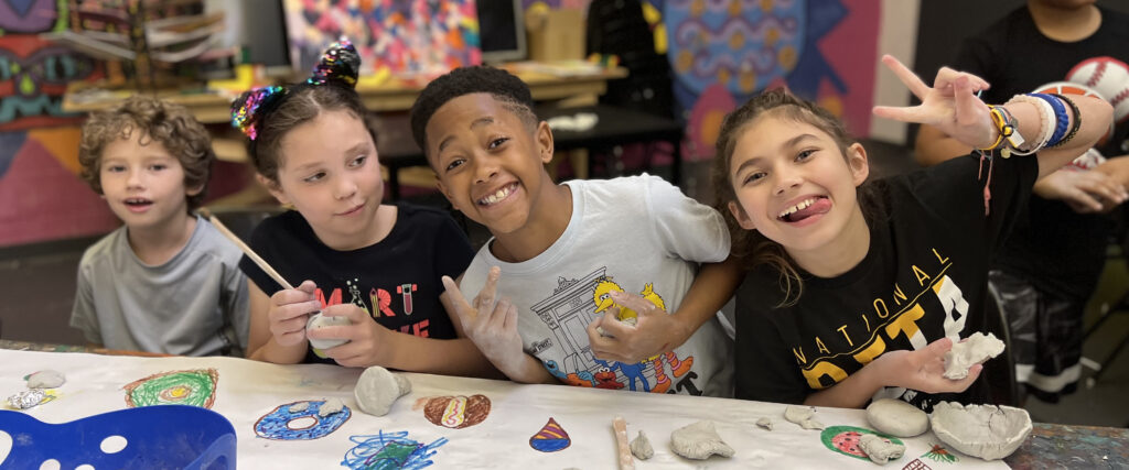 Four kids make faces at camera during art camp