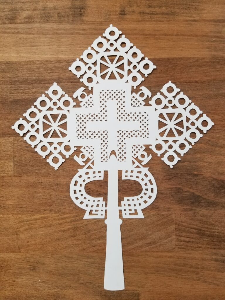 Papercut Ethiopian cross with wooden background