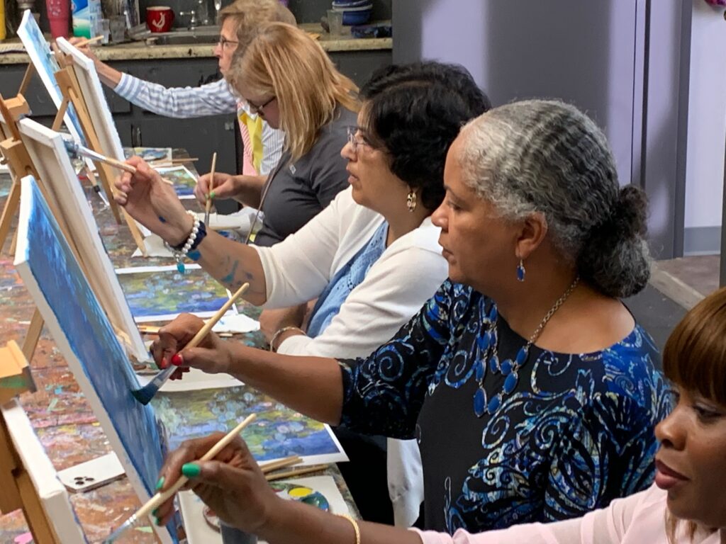 Women paint at a table