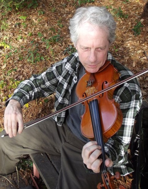 Man plays violin in outdoor setting