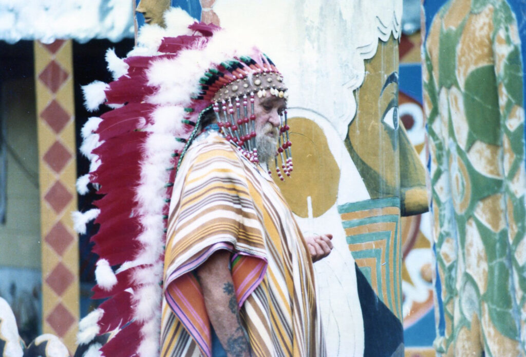 St. EOM is shown at Pasaquan wearing a feathered headdress